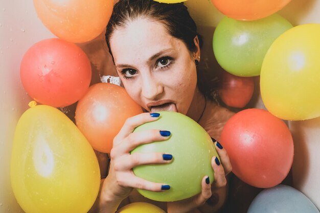 portrait-woman-licking-colorful-balloons-home_1048944-8272543.jpg