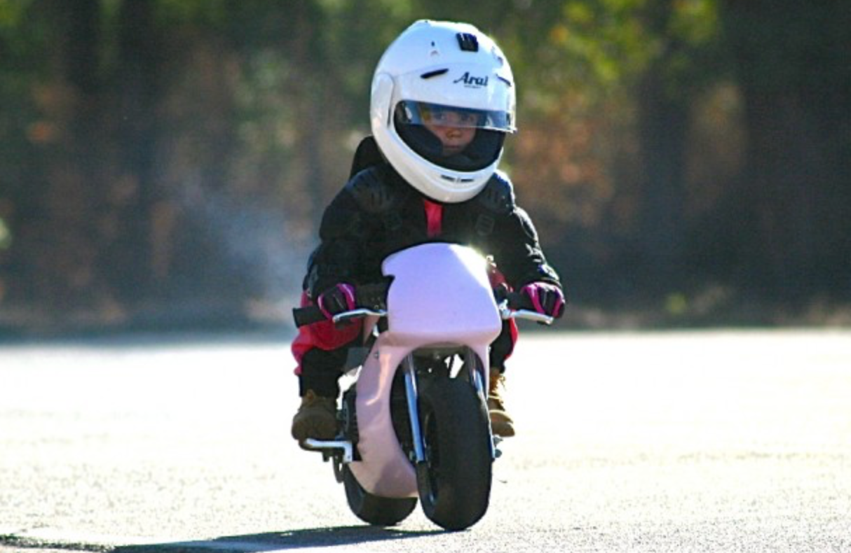 Tiny little girl on pink sport bike copy.png